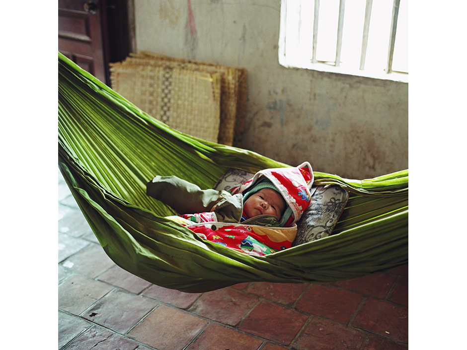 Vietnam - Craft villages - A two month old baby boy asleep in a hammock in Tang Tien a bamboo basket weaving village