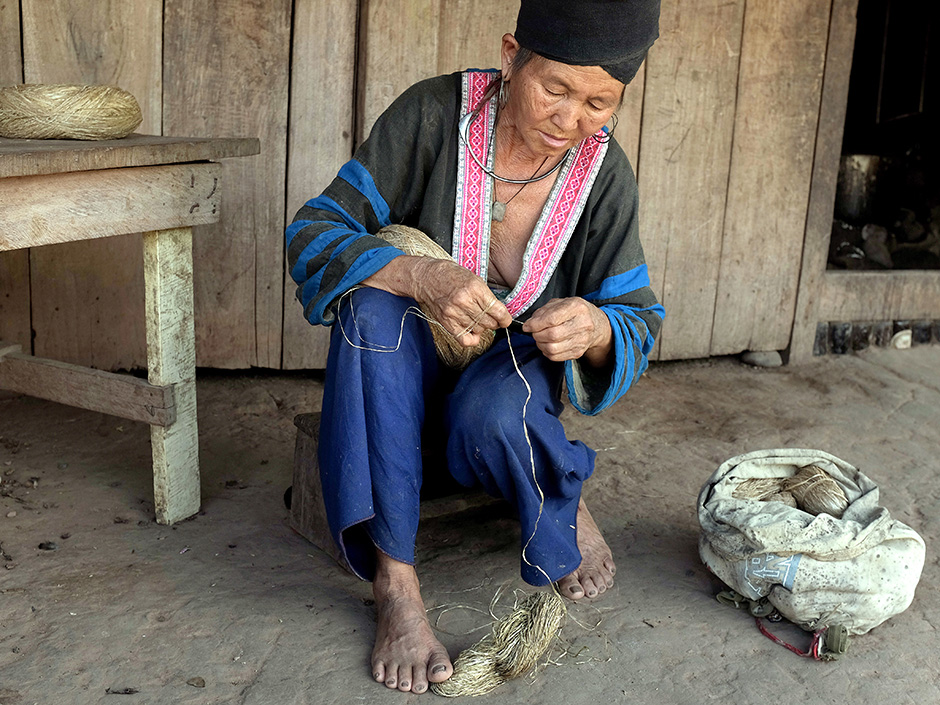 Lao PDR - Ethnic minorities - A Hmong woman winding hemp for making her traditional clothing